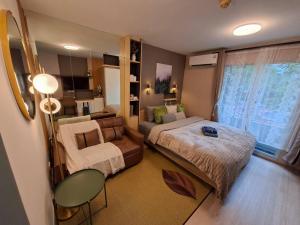 a small bedroom with a bed and a couch at Modern Studio Pool View, King bed, BTS Punnawithi in Bangkok +35 photos