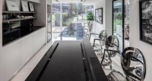 a dining room with a black table and chairs at Modern Studio Pool View, King bed, BTS Punnawithi in Bangkok