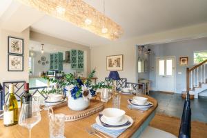 a dining room and living room with a table and glasses at Finest Retreats - The Old Schoolhouse at Penrhos in Raglan