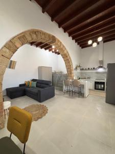 a living room with a couch and a kitchen at Bougainvillea in Asklipiḯon