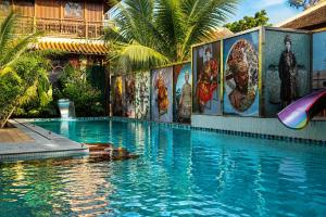 a swimming pool with paintings on the side of a building at Thien Y Villas in Hue