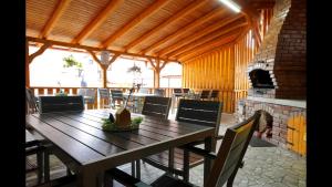 a dining room with a wooden table and a fireplace at Pensiunea Smiley in Turda