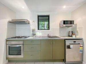 a kitchen with a sink and a stove at Canopy Chalet 10 in Nelly Bay