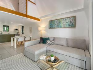 a living room with a couch and a table at Canopy Chalet 10 in Nelly Bay