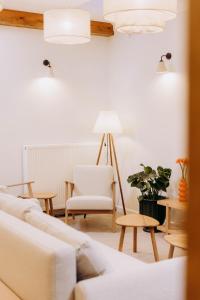 a living room with a white couch and a chair at Luna in Kazimierz Dolny