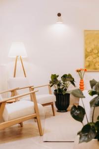 a room with two chairs and a lamp and plants at Luna in Kazimierz Dolny