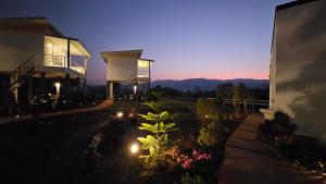 a house with lights in a yard at night at Doi Luang Vista Homestay in Ban Mae To