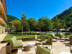 a patio with chairs and tables and a park at Hotel Catalunya Park in Ribes de Freser