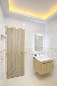 a bathroom with a sink and a wooden door at Chill Sbai Villa Pattaya in Nong Prue +11 photos