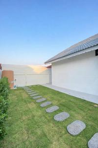 a garden with stepping stones in the grass at Chill Sbai Villa Pattaya in Nong Prue