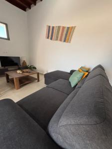 a living room with a gray couch and a table at Bougainvillea in Asklipiḯon