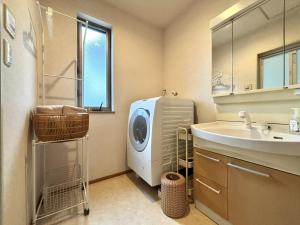 a laundry room with a washing machine and a sink at 湘南で暮らすように泊まる一棟貸し U-house Shonan in Fujisawa