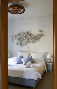 a bedroom with a bed with a painting on the wall at Grand Bleu Apartments & Villas in Ermioni