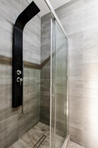 La salle de bains est pourvue d'une douche avec une porte en verre. dans l'établissement Apartament Plac Zbawiciela, à Varsovie