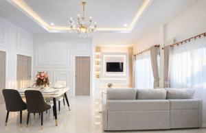 a living room with a couch and a table at Chill Sbai Villa Pattaya in Nong Prue