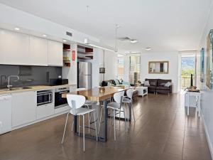 a kitchen and dining room with a table and chairs at 1 Bright Point Apartment 4501 in Nelly Bay
