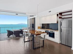 a kitchen with a table and a view of the ocean at 1 Bright Point Apartment 4501 in Nelly Bay
