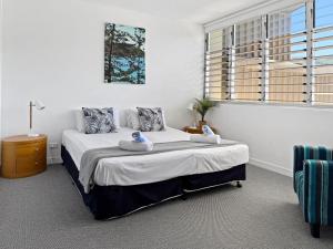 a bedroom with a large bed and a window at 1 Bright Point Apartment 4501 in Nelly Bay
