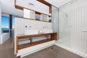 a bathroom with two sinks and a shower at 1 Bright Point Apartment 4501 in Nelly Bay +9 photos