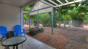 a patio with two blue chairs and a table at Loyang Apartment 2 in Arcadia