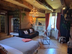a bedroom with a bed and a couch and a chandelier at B&B maison du Saint Cirque in Saint-Dau +24 photos