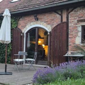 a patio with two chairs and an umbrella at Pokój i Spokój Agroturystyka in Zacisze