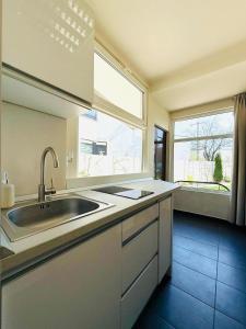 a kitchen with a sink and a large window at Moon Stylish -FREE parking -Romantic City Stay in Timişoara
