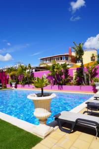 a pool with a fountain and chairs and a building at Casa Concha - Peaceful and Relaxing in Lagos