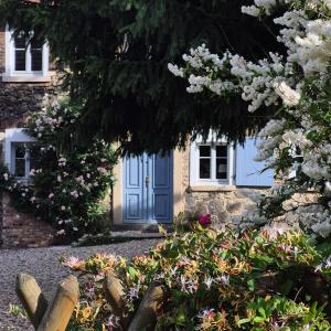 a house with a blue door and some flowers at Pokój i Spokój Agroturystyka in Zacisze