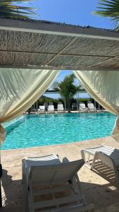 a swimming pool with two lawn chairs and a table at L'oasi del Tuffatore in Agropoli