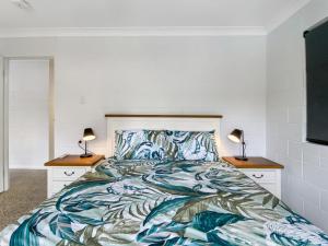 a bedroom with a bed and two night stands at Nerita Nook in Nelly Bay