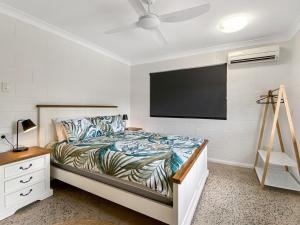 a bedroom with a bed and a flat screen tv at Nerita Nook in Nelly Bay