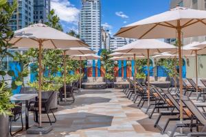 a row of tables and chairs with umbrellas at Pipa Bangkok Sukhumvit 11 by Kingston Hotels in Bangkok