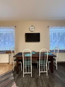 a dining room with a table and chairs and a clock at Apartment Martinec in Nové Město nad Metují