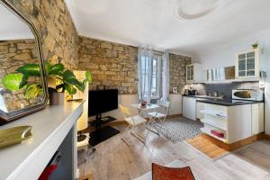 a kitchen with a stone wall and a kitchen with a desk at Appartement centre de Crozon in Crozon
