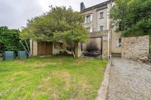 an empty yard with a building and a tree at Appartement centre de Crozon in Crozon