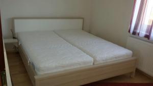 uma cama branca num quarto com uma janela em Modernes 3-Zimmer-Apartment nahe Graz em Gratkorn