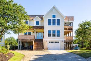 a large white house with a garage at Duck Resort with Ocean Views Pool HotTub Elevator in Kitty Hawk Beach