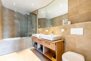 a bathroom with two sinks and a shower and a toilet at Ferienvilla Bad Schandau in Bad Schandau +49 photos