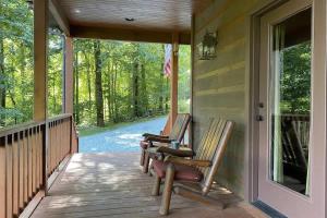 two rocking chairs sitting on the front porch of a house at Millstone Lodge Cabin in Bryson City
