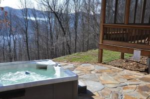 a jacuzzi tub in the backyard of a house at Millstone Lodge Cabin in Bryson City