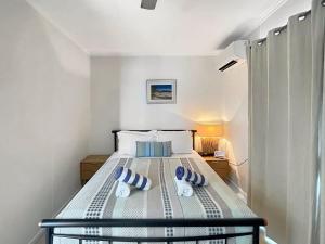 a bedroom with a bed with blue pillows on it at Blue on Cockle in Picnic Bay