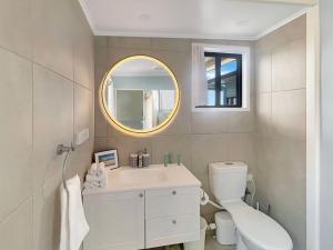 a white bathroom with a sink and a mirror at Blue on Cockle in Picnic Bay +19 photos