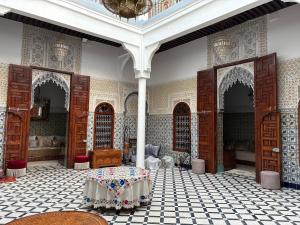a room with a table in the middle of a building at Riad El abrar in Salé