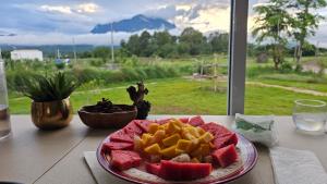 a plate of fruit on a table in front of a window at Doi Luang Vista Homestay in Ban Mae To
