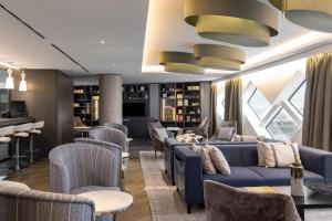 a hotel lobby with couches and chairs and a bar at Hilton Amsterdam Airport Schiphol in Schiphol