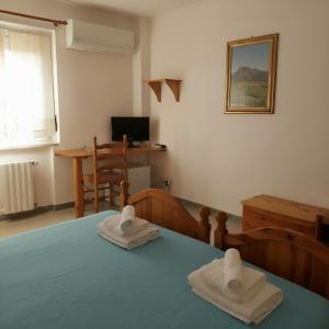 a room with a bed with two towels on it at Borgo Moderno in Irgoli