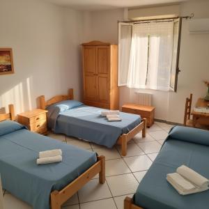 a room with three beds and a window at Borgo Moderno in Irgoli