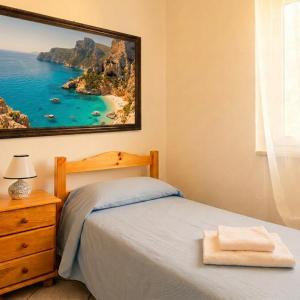 a bedroom with a bed and a painting on the wall at Borgo Moderno in Irgoli