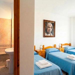 a room with two beds and a sink and a mirror at Borgo Moderno in Irgoli +5 photos